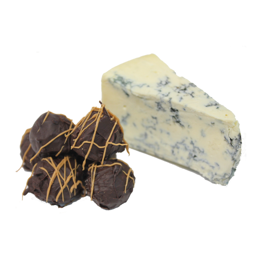 A stack of chocolate truffles with blue vein cheese centre sitting next to a chunk of blue vein cheese