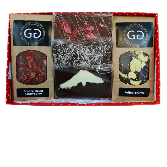 Red spotted box containing a mixture of Giles chocolatier bars and truffles